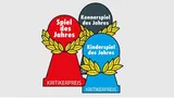 Three pawn-shaped awards with laurel wreaths. The red award reads "Spiel des Jahres" and "KRITIKERPREIS". The dark gray award reads "Kennerspiel des Jahres". The blue award reads "Kinderspiel des Jahres" and "KRITIKERPREIS".