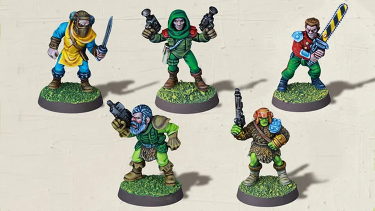 Five colorful tabletop miniatures are displayed on grassy bases. The characters include a blue-clad figure wielding a sword, a green-robed character with a firearm, a bearded figure in green armor holding a weapon, a green-skinned character with a bandolier and a gun, and a red and blue armored figure also brandishing a firearm. Each miniature features distinct details and vibrant colors, showcasing a variety of fantasy and sci-fi elements.