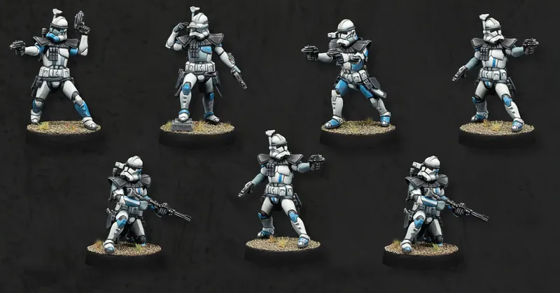 Seven Advanced Recon Commandos (ARC troopers) are depicted in the image, showcasing their distinctive white armor with blue accents. Each miniature is posed differently, some aiming weapons while others are in various stances, all standing on textured bases with a grassy appearance. The background is a solid black, emphasizing the details and colors of the troopers.