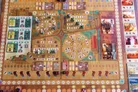 A board game titled Diables with a medieval village layout. Miniature devil figures, drummers, and buildings populate the map. Central area shows a circular arena with numbered spaces and devil icons. Cards with devil illustrations and text are placed on the board.
