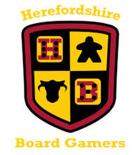 A shield-shaped logo features a divided design with four quadrants. The top left quadrant displays a red die with black dots, the top right features a black meeple, the bottom left shows a black cow silhouette, and the bottom right has a red die with white dots. The text "Herefordshire Board Gamers" is prominently displayed above and below the shield in a bold, yellow font.