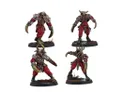 Four miniatures are displayed, each featuring a distinct design with a combination of red and gray colors. The figures have exaggerated, muscular forms, with claw-like hands and various armor pieces, suggesting a fierce and aggressive appearance. They stand on black bases, with some having additional details like bone or horn accents, emphasizing their menacing and otherworldly nature.