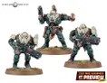 Three miniature figures from the Leagues of Votann are displayed on a grassy base. The central figure, slightly taller, is equipped with a pistol and has a distinctive armor design featuring green and beige colors, along with a decorative belt. The two flanking figures are shorter, one holding a large futuristic weapon, while the other has a more relaxed stance with a hand raised, possibly gesturing. All three figures exhibit a robust, armored appearance typical of the faction's aesthetic.