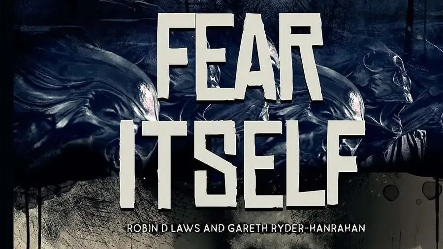 Dark, shadowy figure in hooded coat stands near a cracked wall. A skull with glowing eyes looms in the background. Text reads: "FEAR ITSELF" in bold white letters, with smaller text below: "ROBIN D LAWS AND GARETH RYDER-HANRAHAN." Scattered bats fly around.