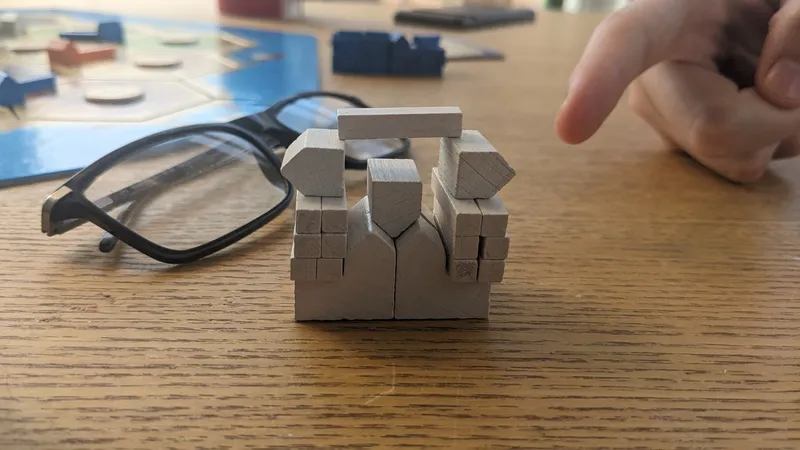 The Catan pieces stacked up in a way to look a tiny bit like a tiny citadel