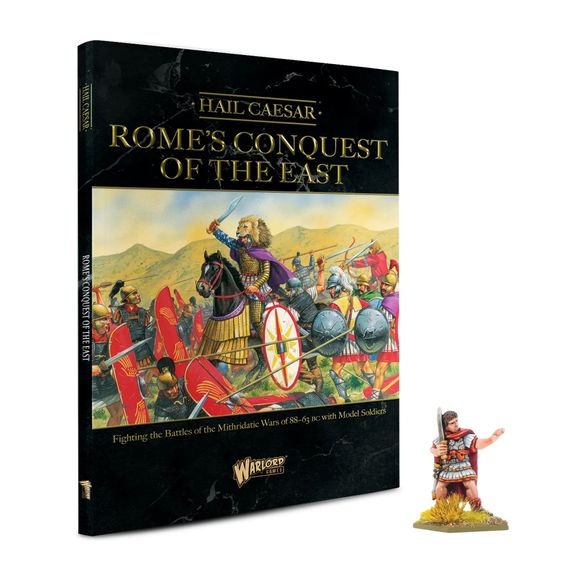 A book titled "Rome's Conquest of the East" from the Hail Caesar series is prominently displayed, featuring a colorful illustration of ancient warriors in battle, including a mounted figure in a purple cloak. The book cover includes the subtitle "Fighting the Battles of the Mithridatic Wars of 88-63 BC with Model Soldiers." Next to the book, there is a miniature figure of Julius Caesar, depicted in early Roman armor, holding a sword and standing on a small base with grass.