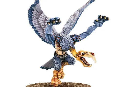Miniature of a Greater Daemon of Tzeentch with blue-grey skin, golden wings, and ornate armor. Standing on a round base, holding a staff in one hand and a skull-like head in the other. Text in top right corner reads "Warhammer Community."