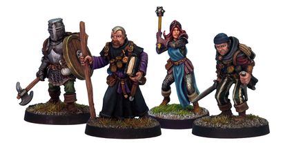 A group of four detailed miniatures representing classic adventurer character classes. On the left, a knight in armor holds a shield, followed by a robed figure with a book and staff. The third figure is a female illusionist in a blue dress with a staff, and on the right, a rugged fighter brandishes a sword. Each miniature is mounted on a round base with grass detailing.