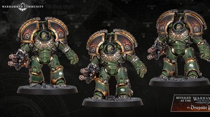 Two imposing Space Marine dreadnoughts stand side by side, showcasing intricate details and a striking green armor adorned with gold accents. Each dreadnought is equipped with a powerful weapon in one hand, featuring a fiery muzzle, while their other arms are armored and decorated with the iconic Aquila symbol. The backdrop is a dark, textured surface with faint maps and symbols, enhancing the dramatic presentation of these new miniatures.