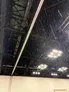 Indoor convention center ceiling with heavy rain leaking through, lights on.