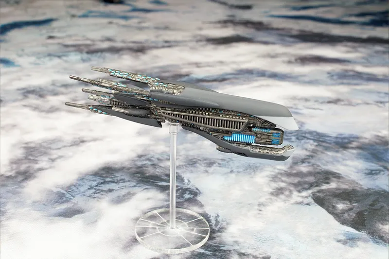 Grey spaceship model with blue lights on a clear stand against a cloudy background.