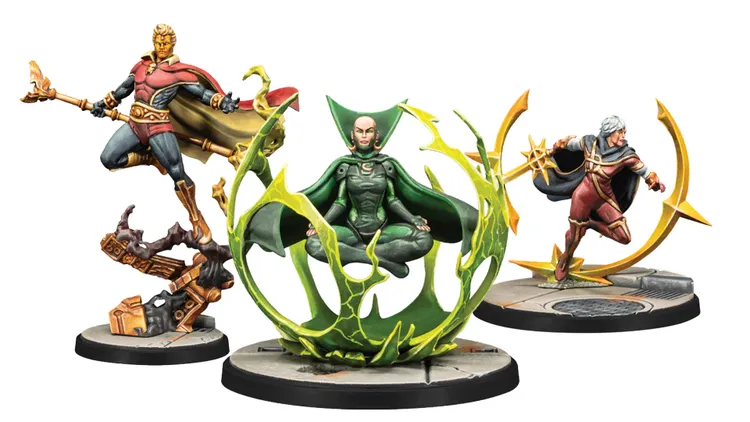 Three detailed miniatures are displayed on a circular base. In the center, a figure in a green cloak is levitating within a swirling green energy ring, showcasing intricate details on her attire and expression. To the left, a muscular character in a red and blue costume stands confidently, while to the right, another figure in a red and black outfit wields a staff, both featuring dynamic poses and vibrant colors.