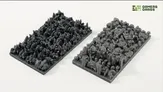 Two rectangular trays filled with gray miniature terrain pieces and scatter elements.
