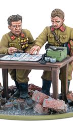 A detailed miniature scene features two Soviet officers, one with a map and the other pointing at it, engaged in strategic planning. They are dressed in military uniforms with insignia, standing beside a table cluttered with a map, a green box, and other items. The base is set on a rubble-strewn ground, with a small animal visible in the foreground, enhancing the war-torn atmosphere.