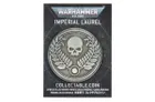 A collectible coin featuring a prominent skull surrounded by laurel leaves, set against a dark, starry background. The coin is labeled "IMPERIAL LAUREL" at the top and "COLLECTABLE COIN" at the bottom, with additional text in multiple languages. The design reflects the Warhammer 40,000 theme, emphasizing its collectible nature.