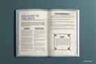 Open book with text and decorative borders on a teal background.