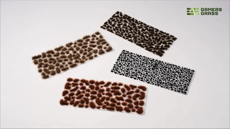 Four rectangular trays with various model grass tufts and basing bits.