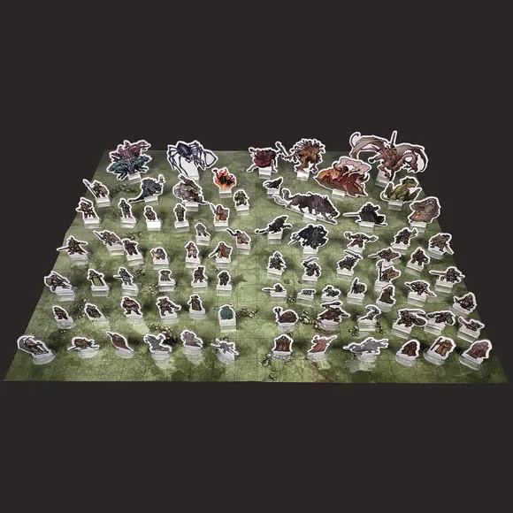 Cardboard standees of fantasy characters and creatures on a green grid map.