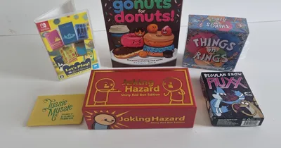 "gonuts for donuts!", "THINGS in RINGS", "Joking Hazard", "Regular Show FLUXX" board game boxes on a white surface.