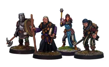 A group of four detailed miniatures representing classic adventurer character classes. On the left, a knight in armor holds a shield, followed by a robed figure with a book and staff. The third figure is a female illusionist in a blue dress with a staff, and on the right, a rugged fighter brandishes a sword. Each miniature is mounted on a round base with grass detailing.