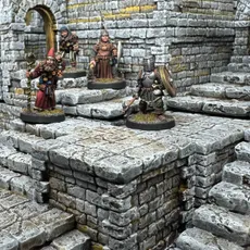 A detailed scene showcases a modular dungeon setup made from intricately sculpted stone blocks, featuring various levels and staircases. Four miniatures are positioned on the blocks: a bearded wizard with a staff, a robed figure holding a spear, and a knight in armor wielding a weapon, all engaged in exploration. The textured stone surfaces and the overall layout highlight the versatility of the dungeon blocks for tabletop gaming.