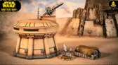 A detailed terrain setup features a sandy landscape with a large, weathered structure in the background, showcasing various mechanical elements and textures. In the foreground, a small, futuristic outpost with a rounded top is positioned next to a covered crate, while a small creature with blue wings and a scaly body rests nearby. The overall scene evokes a desolate yet intriguing atmosphere, suitable for tabletop gaming.