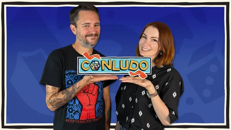 Two people holding a sign reading "CONLUDO" against a blue background.