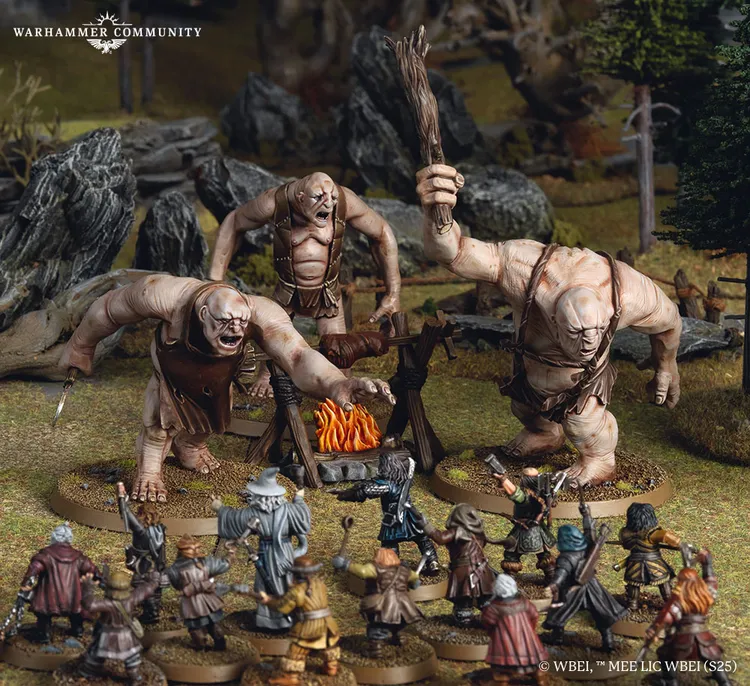 Three large trolls, each with distinct features and wielding makeshift weapons, are positioned around a campfire in a forested setting. In the foreground, a group of characters from Thorin's Company, including dwarves and a wizard, are depicted in various poses, preparing for confrontation. The scene captures the tension of the moment, with detailed terrain elements like rocks and trees enhancing the atmosphere.