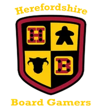 A shield-shaped logo features a divided design with four quadrants. The top left quadrant displays a red die with black dots, the top right features a black meeple, the bottom left shows a black cow silhouette, and the bottom right has a red die with white dots. The text "Herefordshire Board Gamers" is prominently displayed above and below the shield in a bold, yellow font.