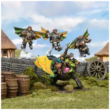 Three halfling pilots with mechanical wings soar above a green and brown landscape, each wearing goggles and flight gear. Below them, a halfling rides a vibrant green drakon, which has colorful wings and a determined expression, while barrels and a wooden cart are positioned nearby. The background features thatched-roof buildings and a stone wall, creating a whimsical, fantasy setting.