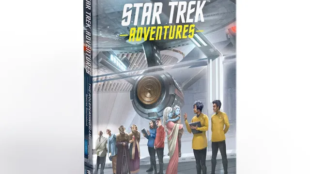 A hardcover book titled "Star Trek Adventures: The Roleplaying Game Species Sourcebook" is prominently displayed, featuring a colorful cover illustration. The scene depicts a diverse group of characters, including various alien species and Starfleet officers, gathered in a futuristic setting resembling a starship interior. The background showcases sleek technology and a large circular device, emphasizing the sci-fi theme of the Star Trek universe.