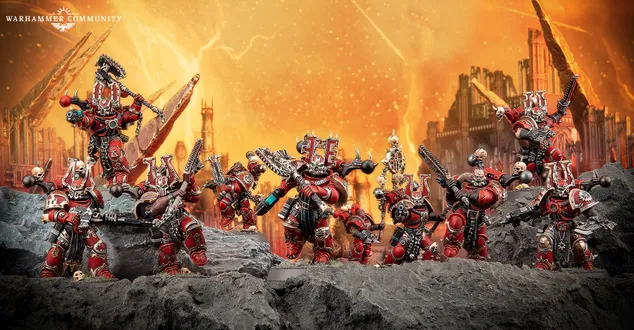A group of World Eaters miniatures stands prominently against a fiery orange background, depicting a chaotic battlefield. The figures are heavily armored, predominantly in red with black and silver details, showcasing various weapons and intricate designs, including a large, imposing character at the center. The rocky terrain beneath them adds to the dramatic atmosphere, emphasizing their fierce presence in the Warhammer 40k universe.