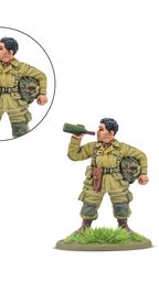 A 28mm miniature of an American paratrooper named "Thirsty Work" is depicted, holding a bottle of wine in one hand while the other arm is posed to hold a pistol. The soldier is dressed in a light green uniform with a backpack and a belt, standing on a grassy base. An inset shows a close-up of the arm holding the pistol, emphasizing the dual options for the model.