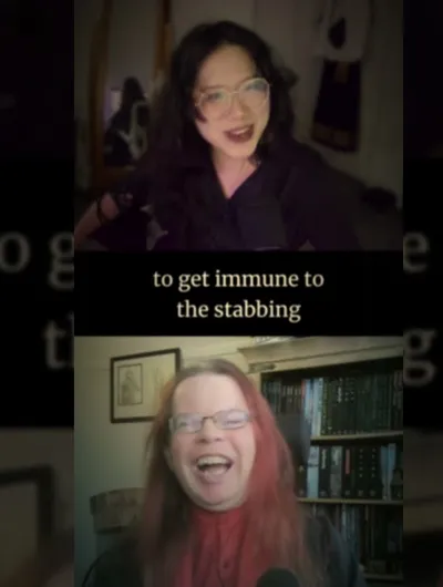 Two individuals are engaged in a lively conversation, with one person on the top half of the image and the other on the bottom. The person at the top has dark, wavy hair and is wearing glasses, while the person at the bottom has long, reddish hair and is also wearing glasses. The background features shelves filled with books and other items, suggesting a cozy, personal space. Subtitles appear on the screen, with the phrase "to get immune to the stabbing" prominently displayed, adding a humorous and intriguing context to their discussion.