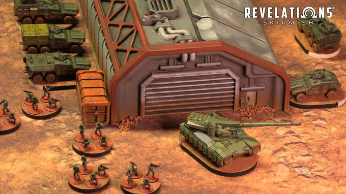 A detailed tabletop scene features a large, industrial building with a corrugated roof and a prominent garage door, set against a textured, sandy ground. In the foreground, several infantry miniatures are arranged in a semi-circle, while a green tank is positioned nearby, showcasing intricate details. Behind the building, additional vehicles are lined up, contributing to the military theme of the setting, with the "Revelations: Skirmish" logo visible in the top right corner.