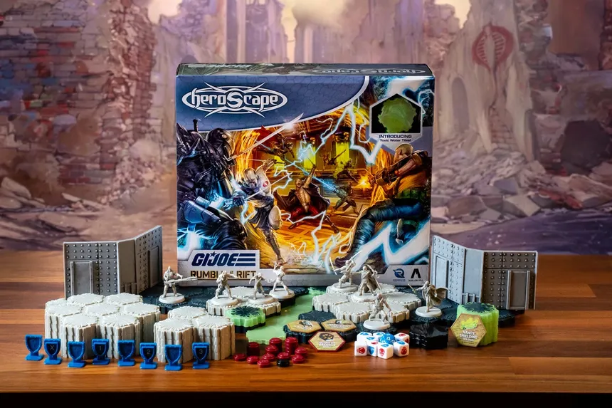 A G.I. JOE Heroscape: Rumble at the Rift Battle Box is prominently displayed in the center, featuring vibrant artwork of characters in action. Surrounding the box are various game components, including eight miniatures representing characters like Duke and COBRA Commander, modular hex terrain pieces, COBRA fortifications, dice, and markers. The background features a blurred, crumbling environment, enhancing the game's adventurous theme.