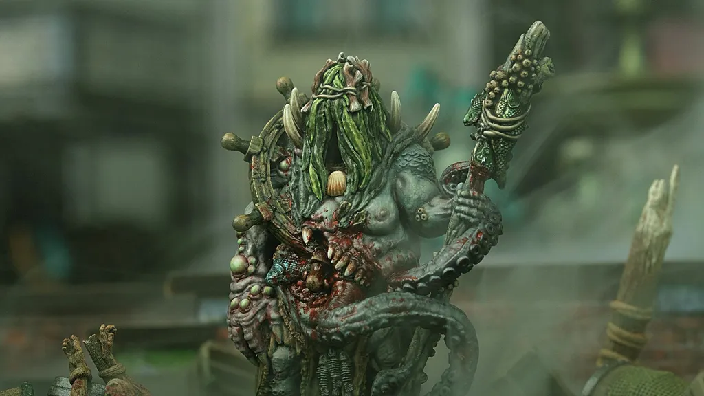 Green-skinned monster with long hair, horns, and a staff, holding a severed head.