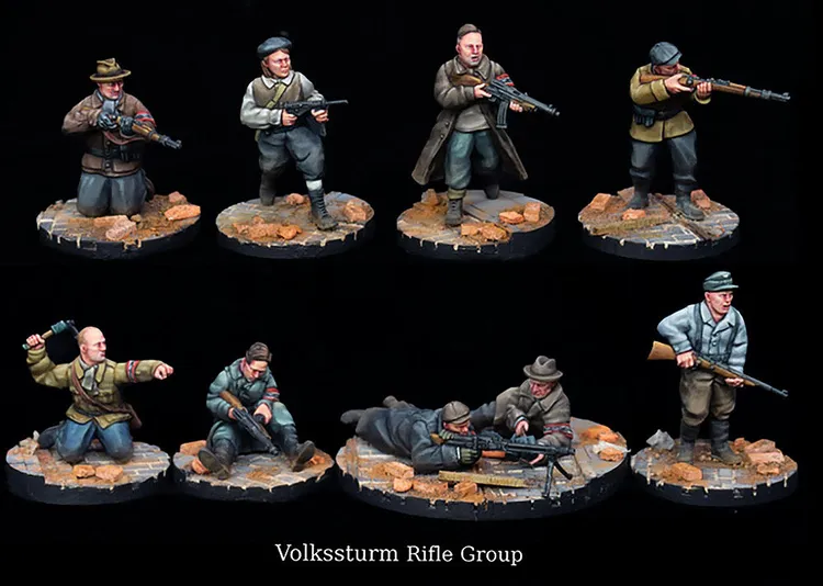 A collection of detailed miniatures representing the Volkssturm Rifle Group, featuring nine figures in various poses. The miniatures are painted in muted colors, showcasing soldiers in period-appropriate uniforms, some holding rifles and others in action stances. Each figure stands on a scenic base with a textured surface, resembling rubble, enhancing the historical context of the scene.