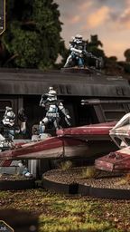 A detailed miniature of the TX-130 Saber-class fighter tank is prominently displayed, featuring a sleek design with a white and red color scheme, equipped with a turret and twin laser cannons. Surrounding the tank are several clone troopers in distinctive armor, posed in various stances, suggesting readiness for action. The backdrop includes a dark, futuristic structure and lush greenery, creating a dynamic battlefield scene.