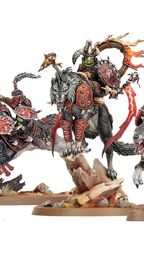 A dynamic display of goblin miniatures features several wolf-riding figures, including a prominent leader adorned with armor and a fiery banner. The miniatures are intricately detailed, showcasing vibrant colors and various weapons, set against a rocky base with tufts of grass. Additional wolf-riders and a chariot can be seen, emphasizing the theme of mobility and aggression in this new release.