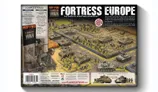 A detailed illustration showcases the "Fortress Europe" starter set for the Flames Of War wargame, featuring a battlefield scene with various military units. In the foreground, a soldier in uniform stands beside a tank, while multiple tanks and infantry figures are arranged across a terrain of fields and barricades. The box cover prominently displays the title "FORTRESS EUROPE" along with images of the included forces, emphasizing the complete World War II starter set.
