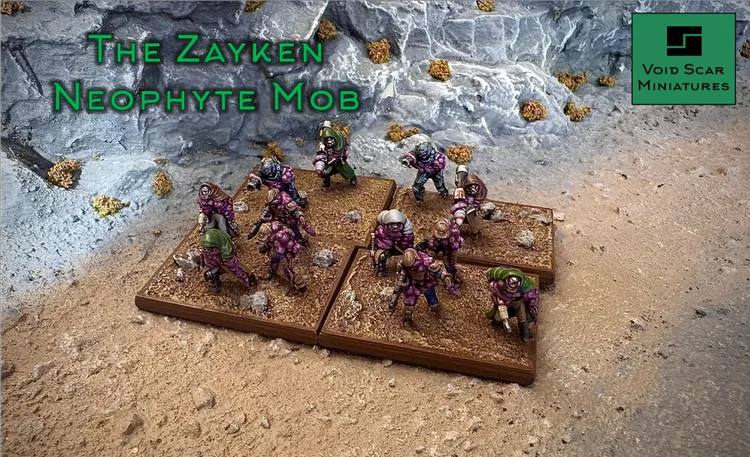 A group of Zayken Neophyte Mob miniatures is displayed on a textured base, featuring a mix of zombified figures in various poses. The miniatures are painted in shades of purple and green, with some holding ranged weapons, while others appear to be unarmed. The background consists of rocky terrain with scattered foliage, enhancing the sci-fi wargaming atmosphere.