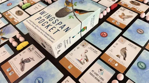 A box labeled "Wingspan Pocket" with illustrations of birds and a nest on a branch. Surrounding the box are game cards featuring bird illustrations, eggs, and buttons. Some cards have visible text such as "AT LEAST 1 CARD TUCKED BEHIND IT", "STARTING HERE, ACTIVATE", and "PLAY A BIRD".