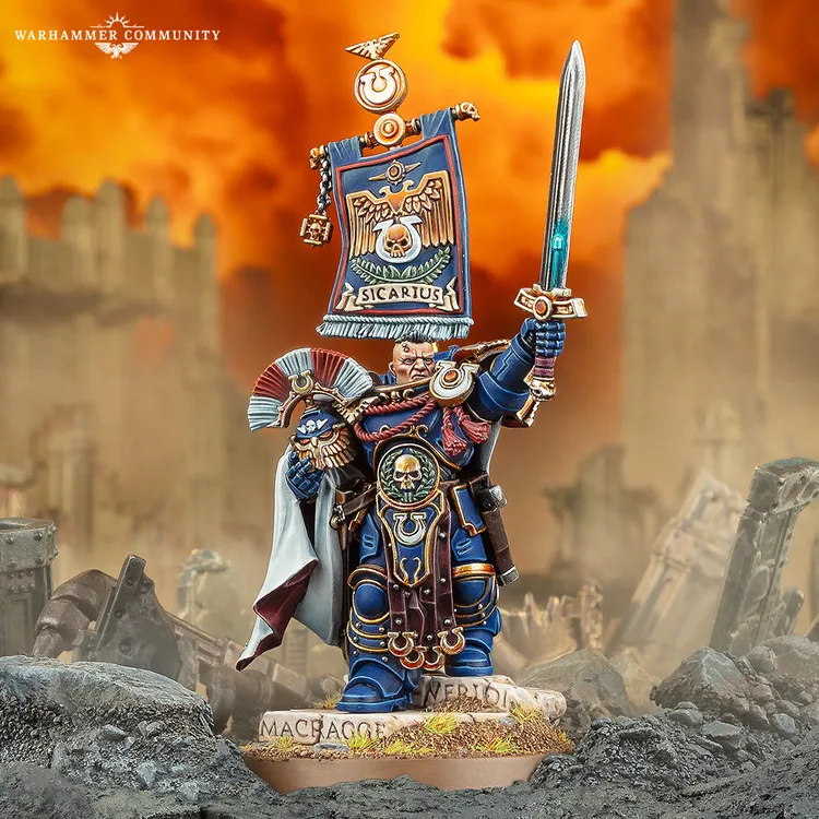 A detailed miniature of Cato Sicarius, a character from the Ultramarines, stands prominently in the foreground. He is adorned in blue and gold armor, holding a glowing sword in one hand and a banner featuring Ultramarine heraldry in the other. The background depicts a war-torn landscape with crumbling structures and a fiery sky, enhancing the dramatic atmosphere of the scene.