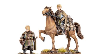 A miniature figure of Lief, a page from Rohan, stands beside a mounted version of himself on a brown horse. The standing figure is dressed in a green and brown cloak, holding a satchel, while the mounted figure wears similar attire and holds the reins of the horse. Both figures are set on a base with tufts of grass and small rocks, emphasizing their connection to the Rohan landscape.
