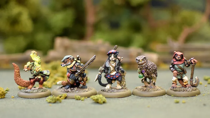 A group of four anthropomorphic miniatures from the game Burrows and Badgers, each character displaying unique features and attire. On the left, a badger holds a rifle, dressed in a green and brown outfit. Next to it, a cat in a blue and red tartan outfit wields a sword. An owl stands in the center, holding a potion, while a rabbit on the right wears a red cloak and holds a dagger. The miniatures are set against a blurred natural background, enhancing their detailed sculpting and painting.