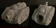 A grotesque tank model designed for a Chaos army, featuring a textured surface adorned with various orifices, boils, and an eye-like detail on the front. The tank has a large, gaping mouth-like opening, emphasizing its disturbing aesthetic. The model is presented in a gray, unpainted finish, showcasing intricate sculpting details that highlight its bizarre and unsettling design.