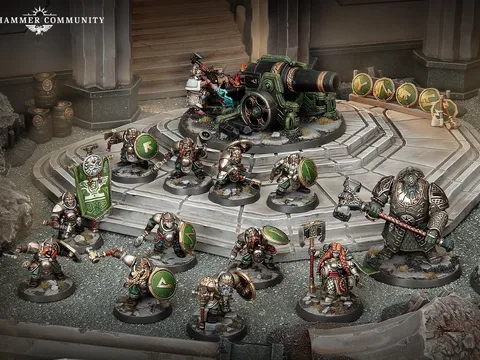 Miniature figures of armored duardin warriors in green and silver plate, standing on a rocky battlefield. One figure holds a large green banner with a white circular emblem. A cannon with a crew of two figures is positioned on a raised platform.