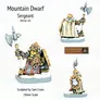 A painted miniature figurine set labeled "Mountain Dwarf Sergeant" with the code "DH16C-03." The set includes three small figures standing on round bases.

The main figure on the left is a dwarf wearing detailed armor with gold and black patterns, a red tunic, and a fur-lined cloak. The dwarf has a braided beard and hair, and holds a large double-bladed axe over one shoulder.

The figure on the right in the background is another dwarf, similarly dressed in ornate armor with a white cloak and gold trim. This figure holds a large warhammer raised in one hand.

The smaller figure at the bottom right wears a cloak with a circular emblem on the back and holds a small axe in one hand.

At the top, the text reads: "Mountain Dwarf Sergeant DH16C-03." Below the figures, the text reads: "Sculpted by Sam Croes 28mm Scale." In the bottom right corner, there is a logo with the text "Alternative Armies."