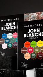 Two sets of John Blanche Masterclass paints are displayed, with Volume 3 on the left featuring a cool color palette, including shades like "Farewell" and "Shadow Thorn," and Volume 4 on the right showcasing warm tones such as "Emberowl" and "Blood Thorn." Both sets are presented in sleek black packaging with vibrant hexagonal labels indicating the paint colors. The background is dark, enhancing the visual impact of the paint sets.